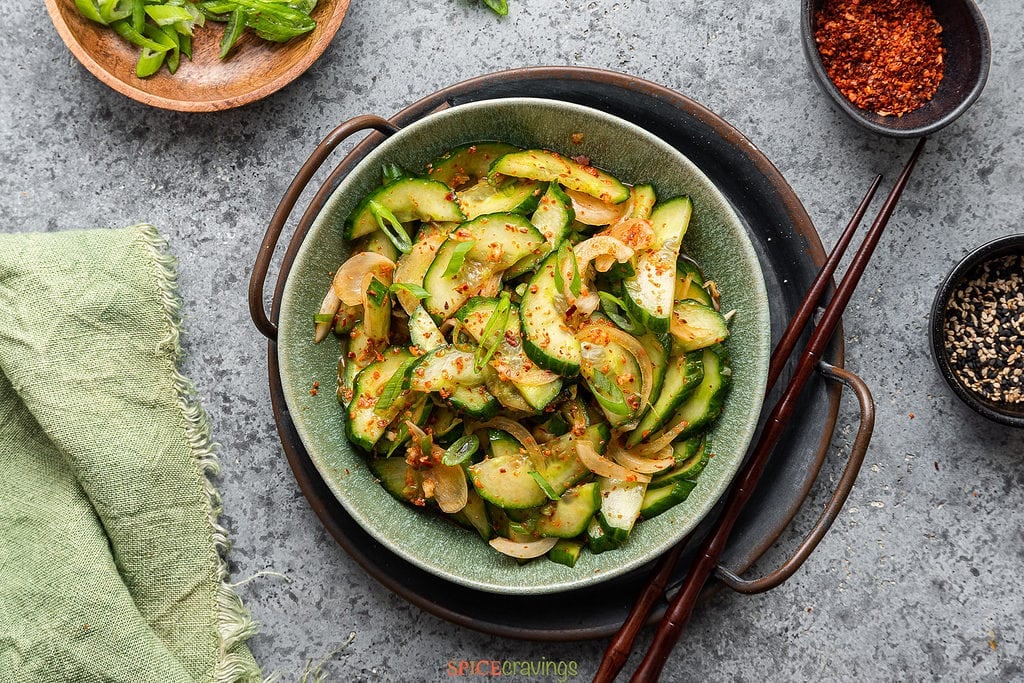 Spicy cucumber pickle with onions in green bowl