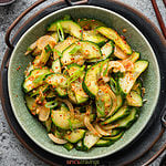 Slices of cucumber with green onion, seasoned with red pepper flakes
