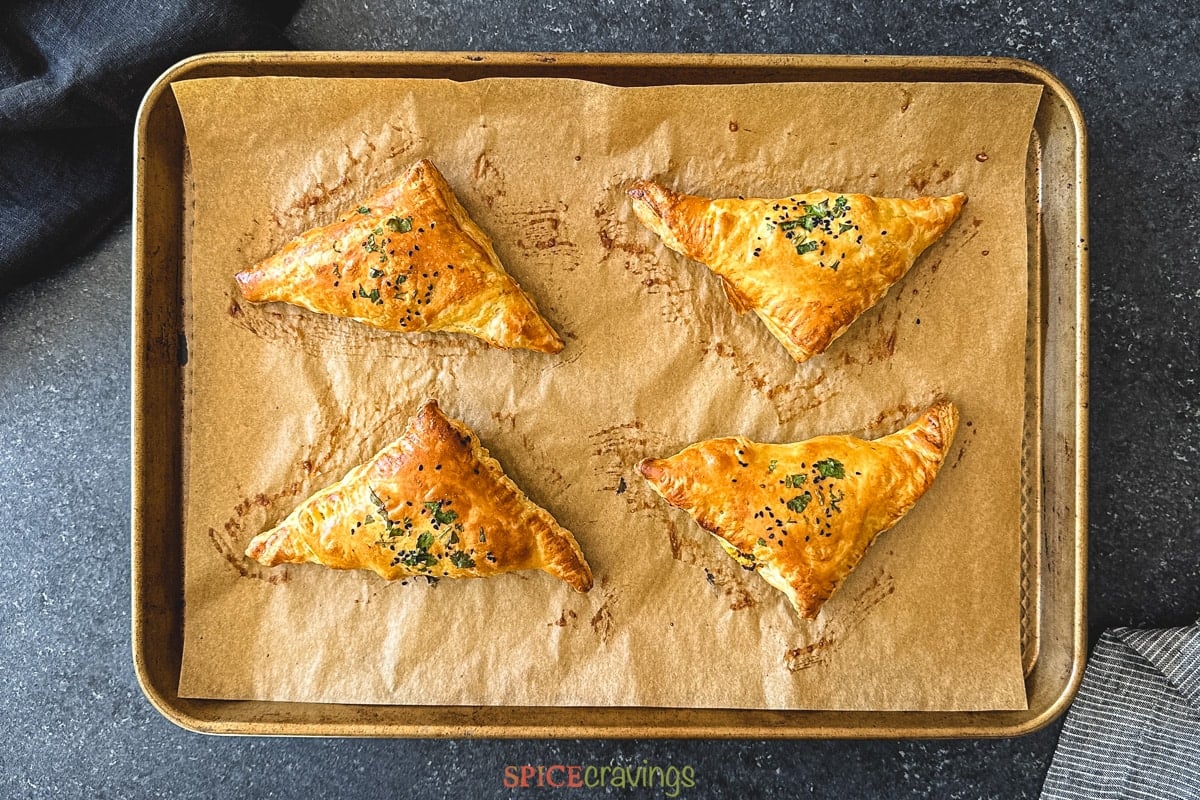 Four golden baked puff pastry triangles