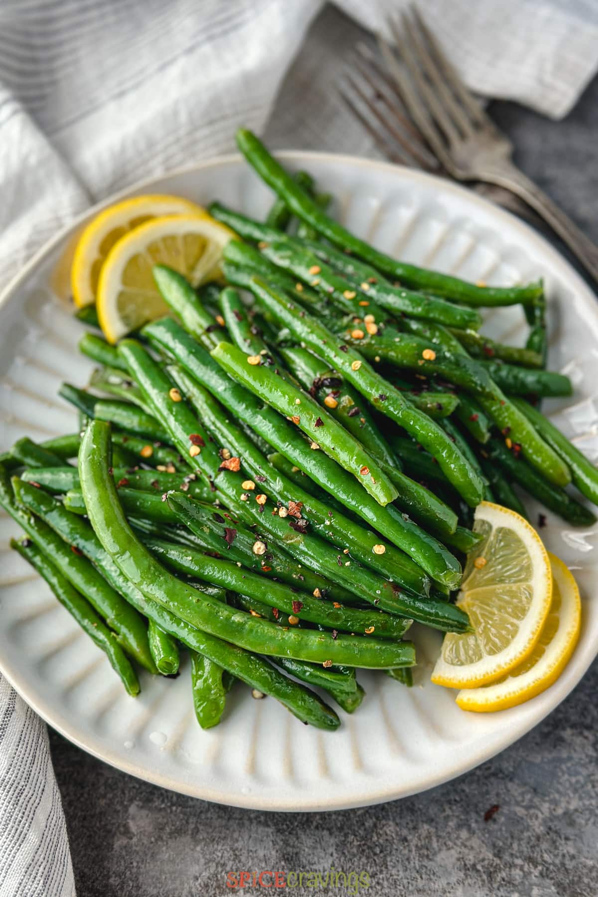 instant pot green beans on white plate with lemon slices
