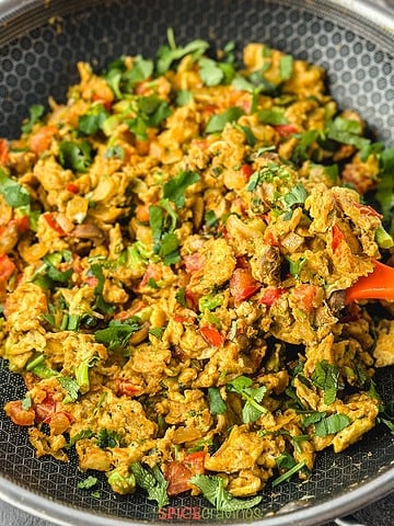 Scrambled eggs with vegetables and cilantro in skillet