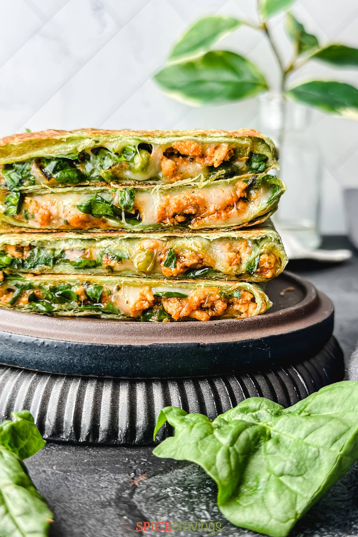 Stack of cheesy quesadillas with meat and spinach