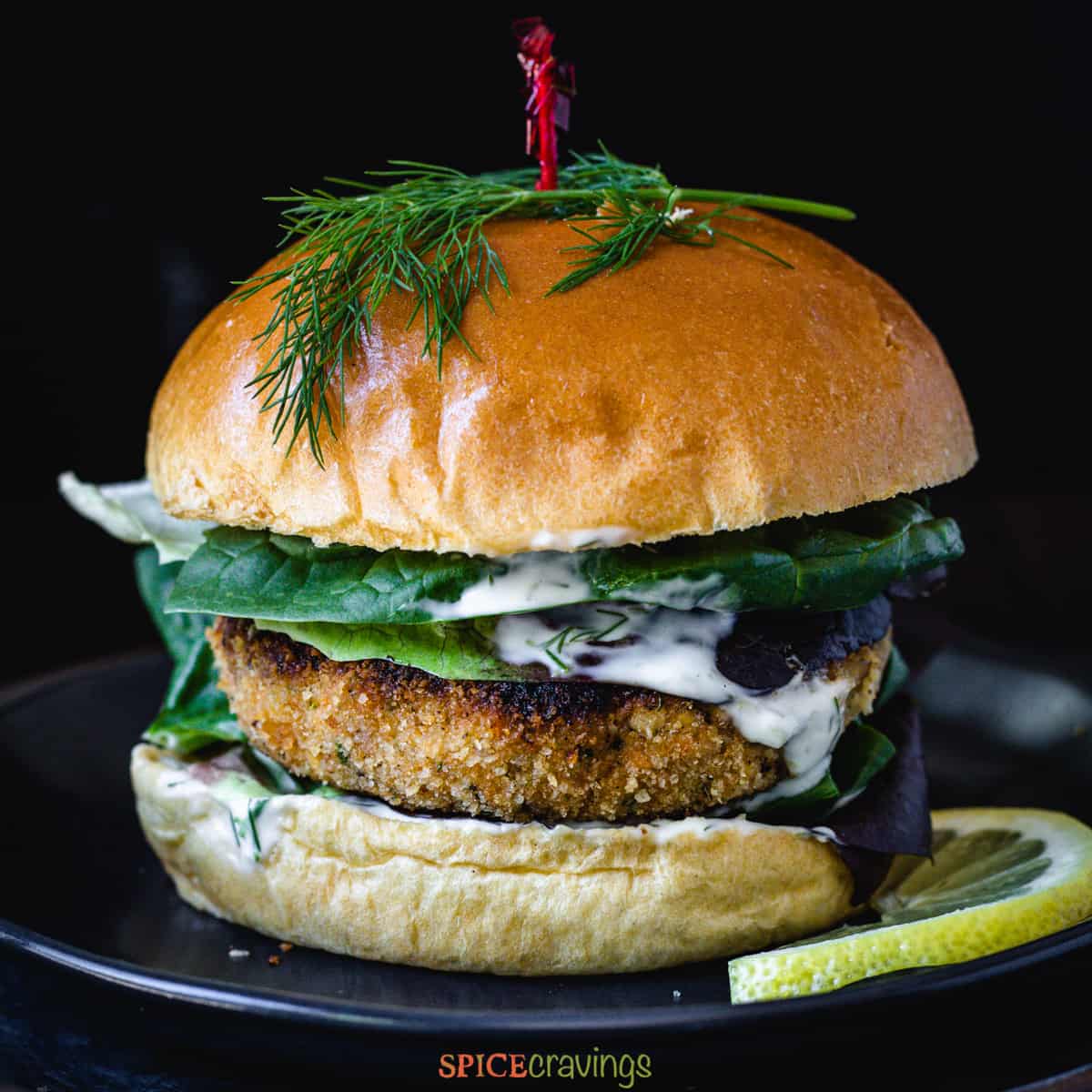 Salmon burger with dill topping and mayonnaise dripping down the patty.