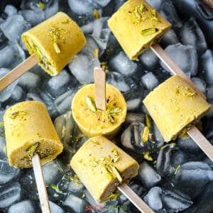 Indian mango ice cream with sticks garnished with sliced pistachio