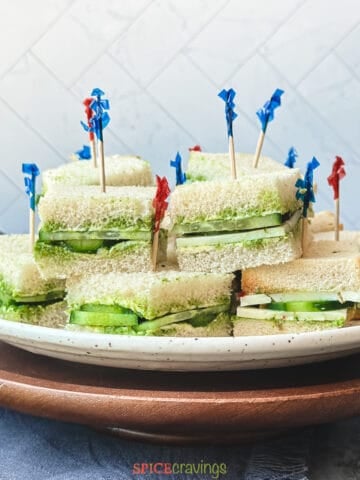 Chutney sandwich with cucumber and cheese stacked on a plate