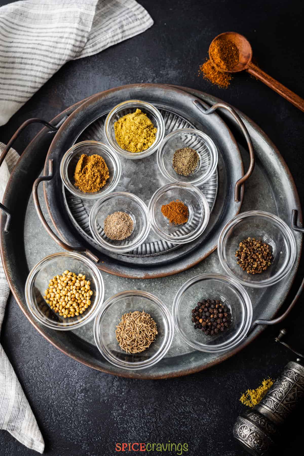 Ground and whole spices on metal plate