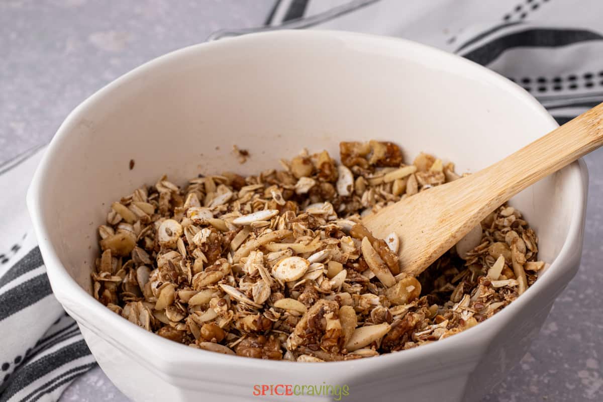 oats, nuts, seeds and spices mixed with sweetener in large bowl