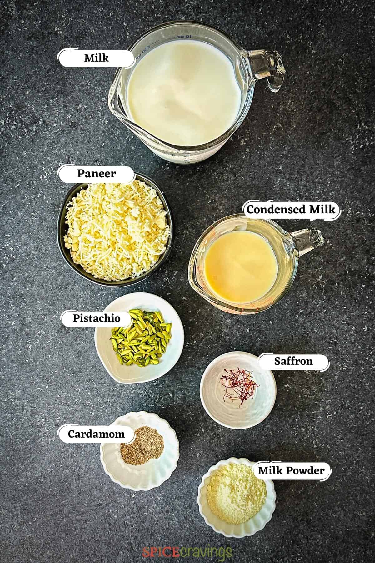 milk, paneer, sugar among other ingredients for making rabdi spread out on grey board