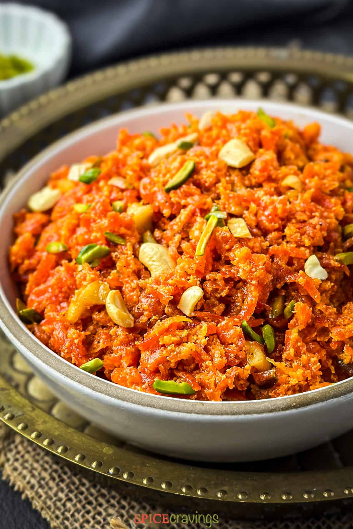 close up of gajar halwa in bowl garnished with assorted nuts