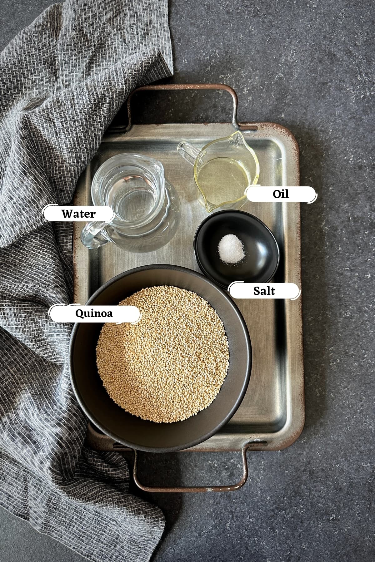 quinoa, water, oil and salt on grey metal tray