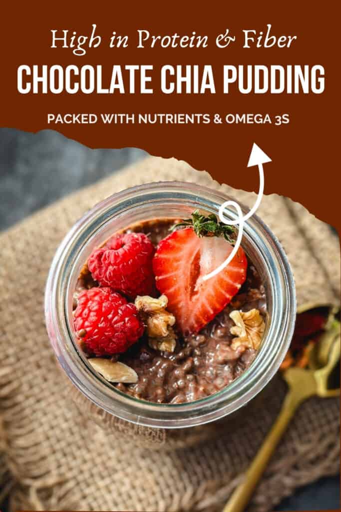 overhead shot of chocolate chia pudding in glass jar topped with berries and nuts