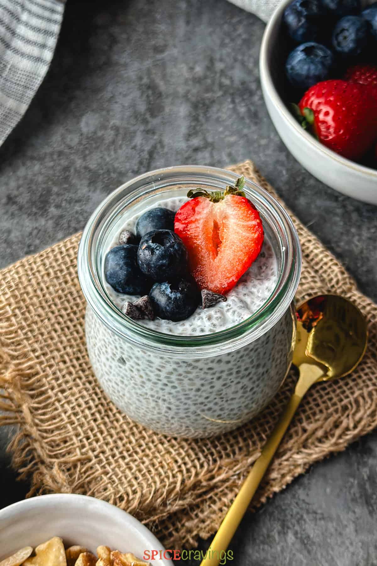 chia pudding with coconut milk in glass jar topped with fresh berries