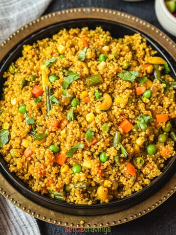 Quinoa and assorted vegetables pilaf in a black bowl