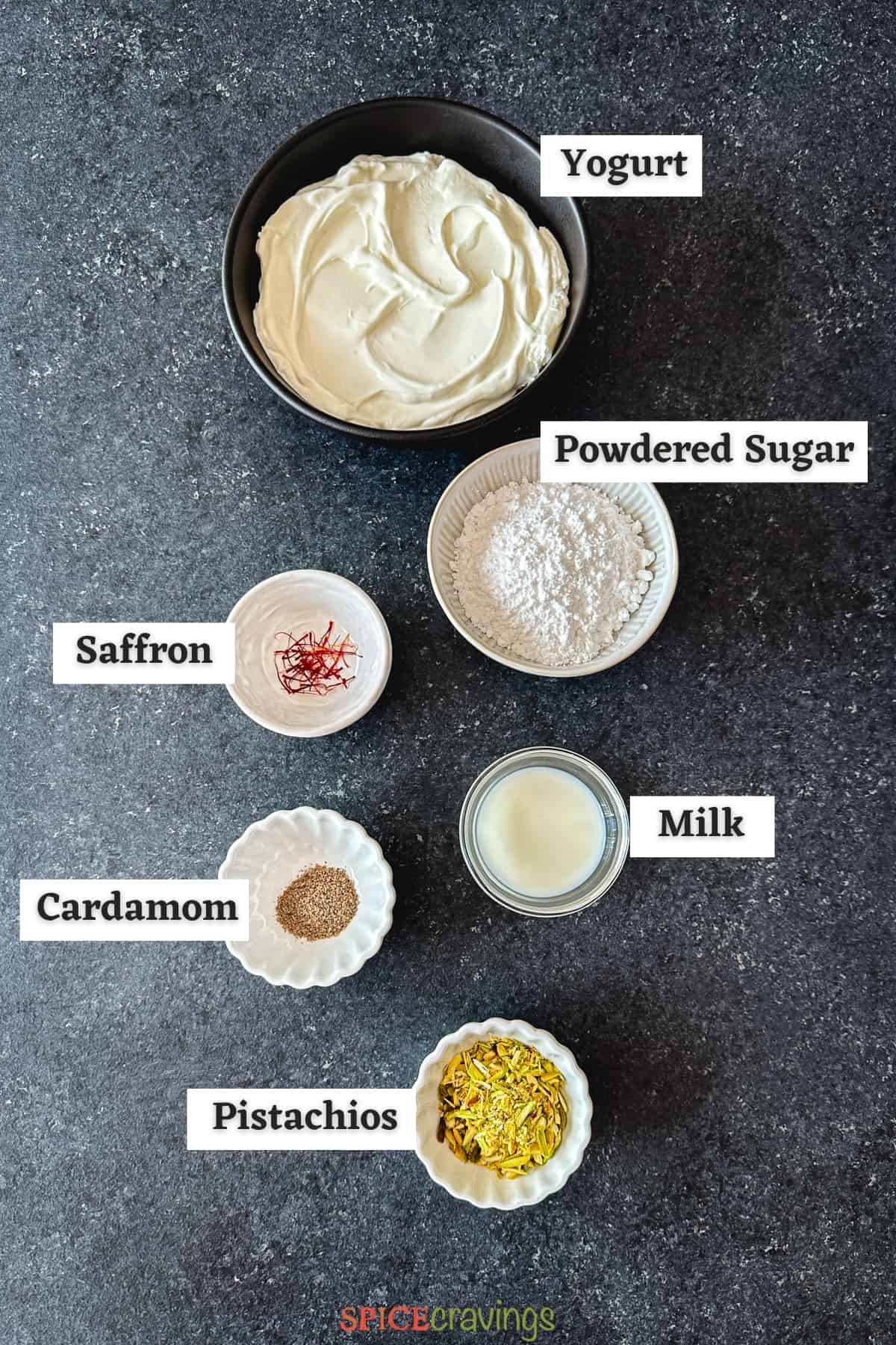 Yogurt, sugar, saffron amond other ingredients on grey board