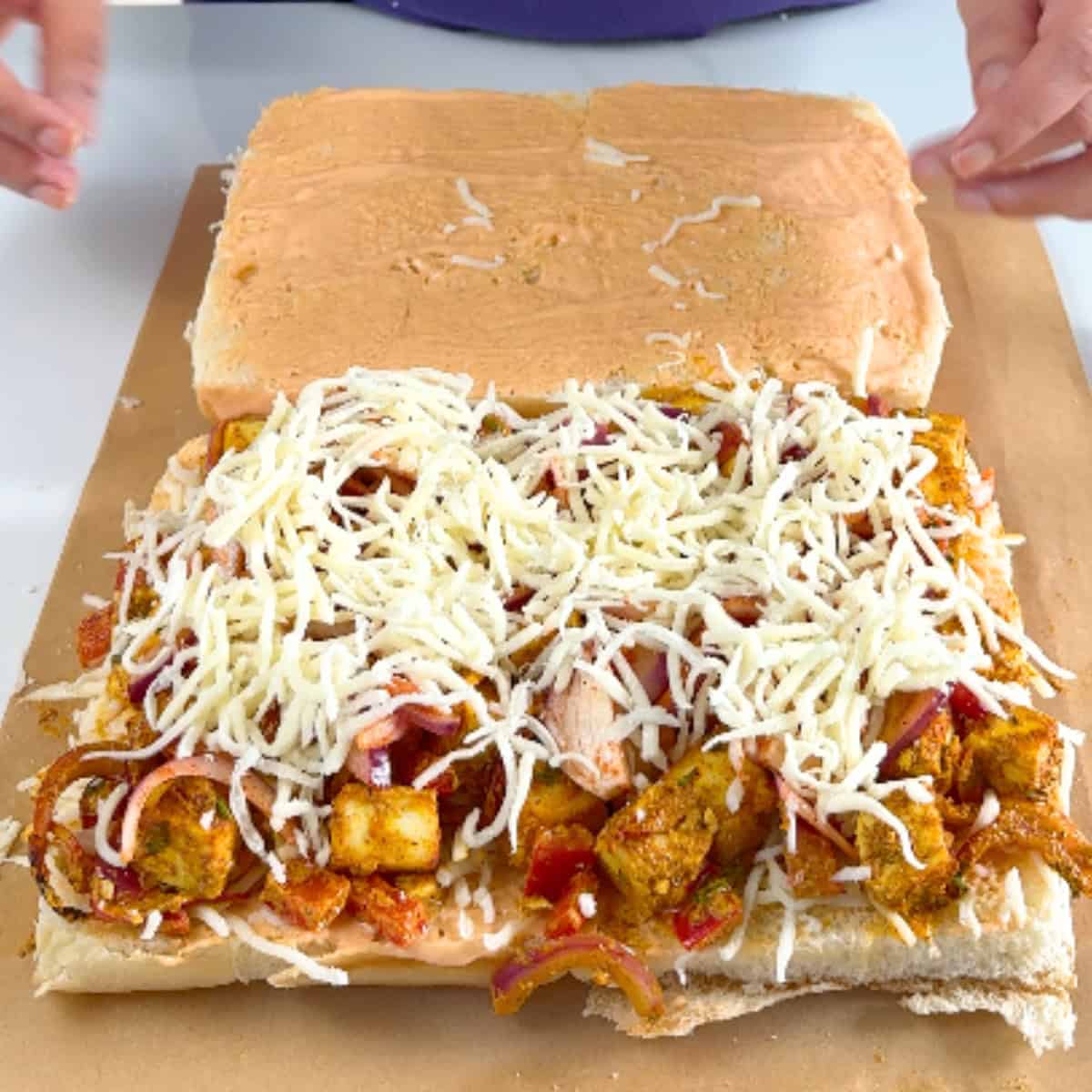 Assembled tandoori paneer and cheese sliders, ready for heating.