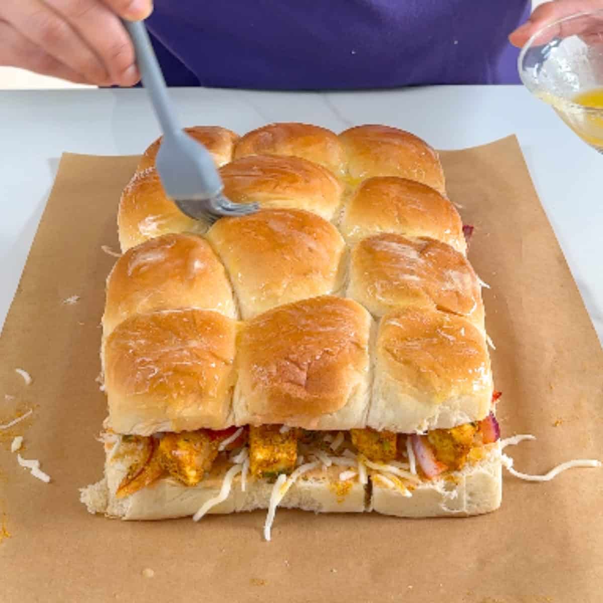 brushing slider rolls with melted butter