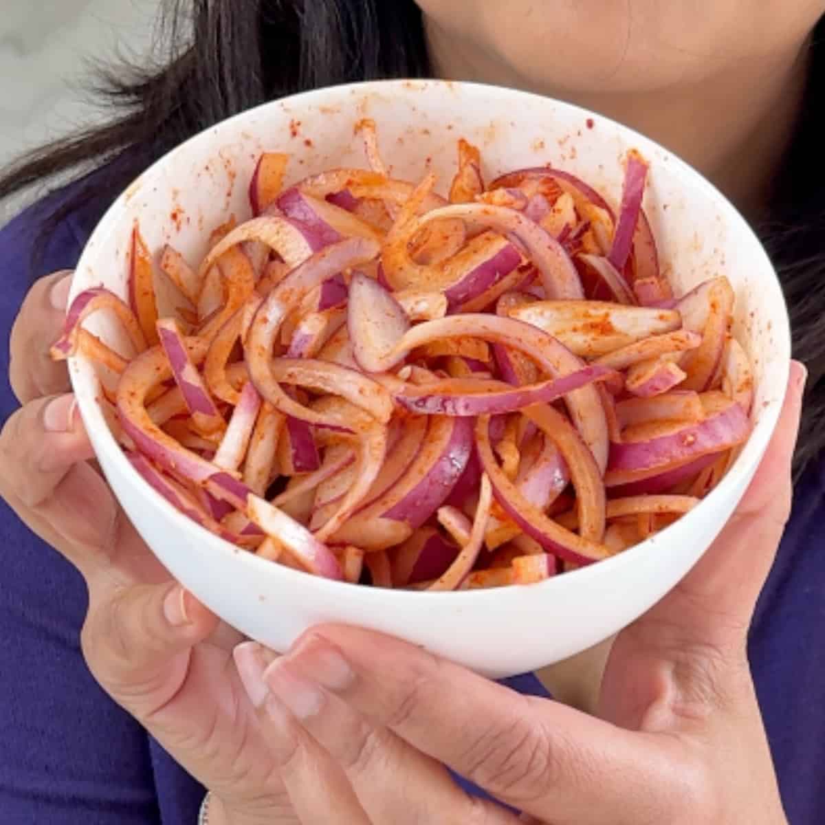 Instant pickled onions in a white bowl with red chili powder, lime and salt