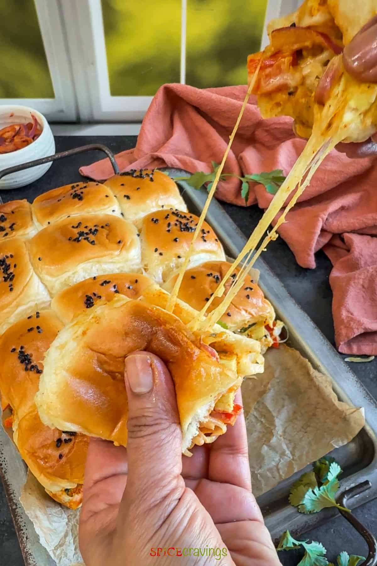 Pulling two sliders apart creating a cheese pull.