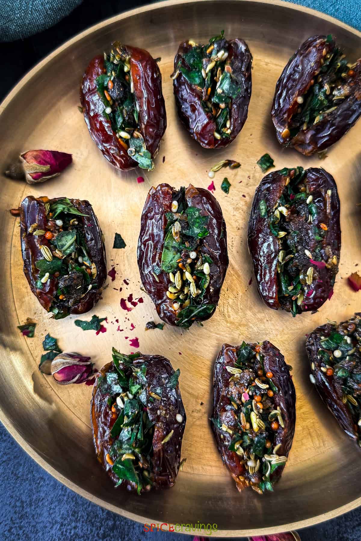 Partial view of A brass plate with stuffed date paan with betel leaves, fennel, gulkand, fennel and mukhwas