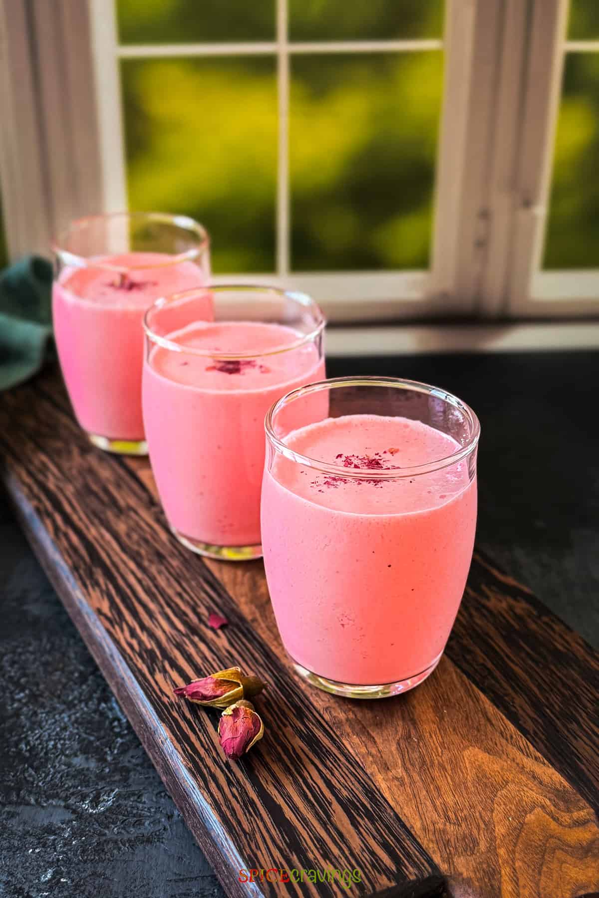 3 shot glasses with the refreshing pink indian yogurt drink called rose lassi, made with rose syrup, yogurt and cardamom