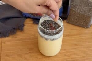sprinkling saffron in a glass with base for mango overnight oats and chia seeds