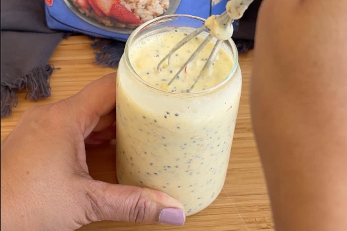 a mini hand whisk in a glass with mango lassi and chia seeds