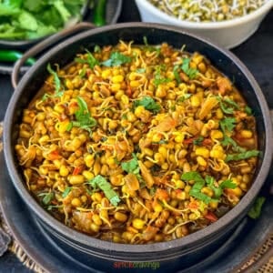 sprouts curry with green moong sprouts in a black bowl garnished with cilantro