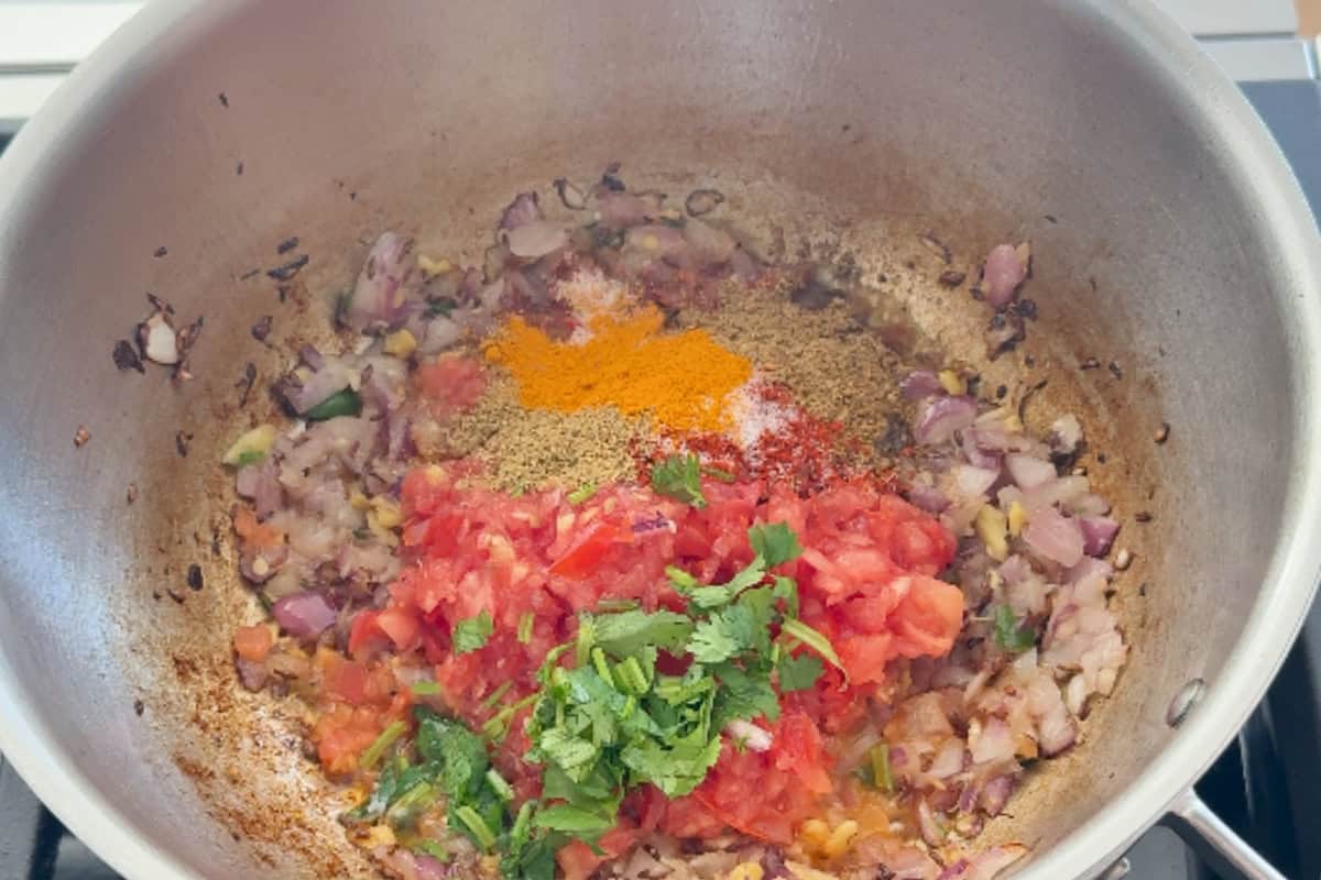 sauteing onion, ginger, garlic, tomatoes and spices in a steel pan